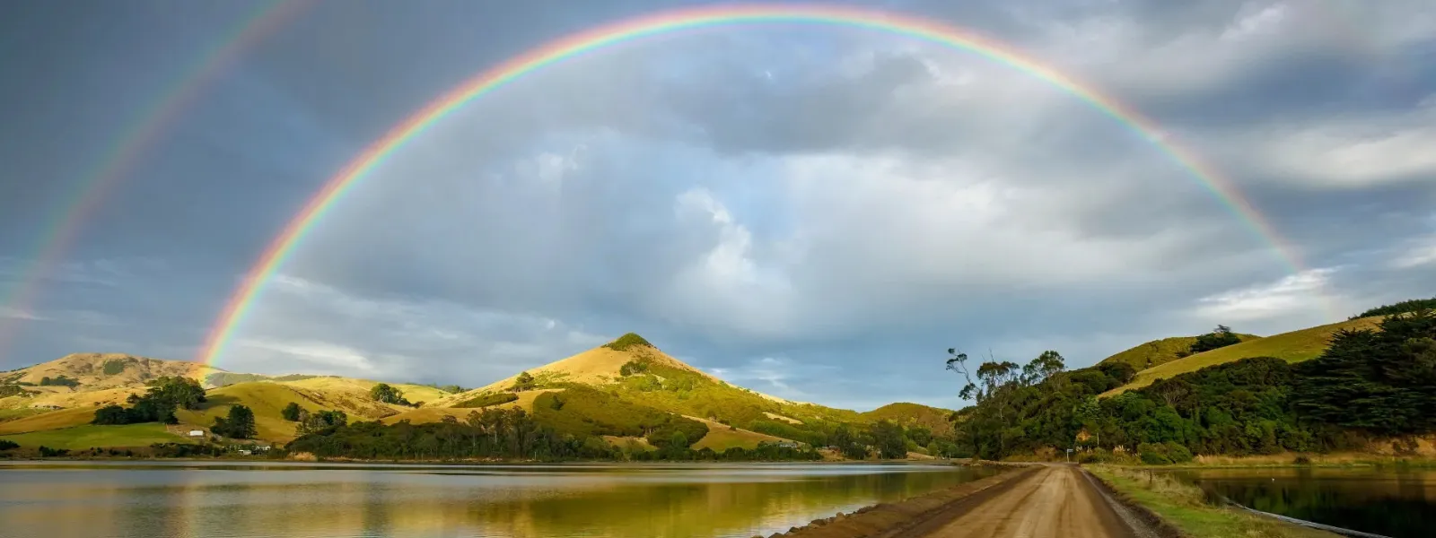 Stunning New Zealand landscape with a rainbow, showcasing the beautiful, clean, and peaceful environment for students