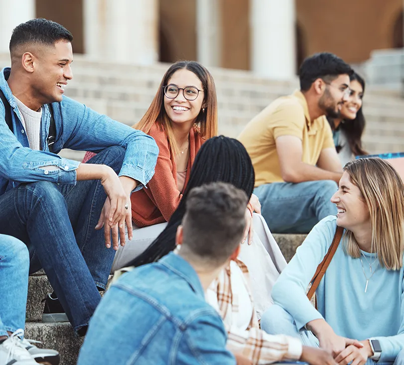 Students socializing on campus steps, enjoying the balanced and relaxed student lifestyle in New Zealand
